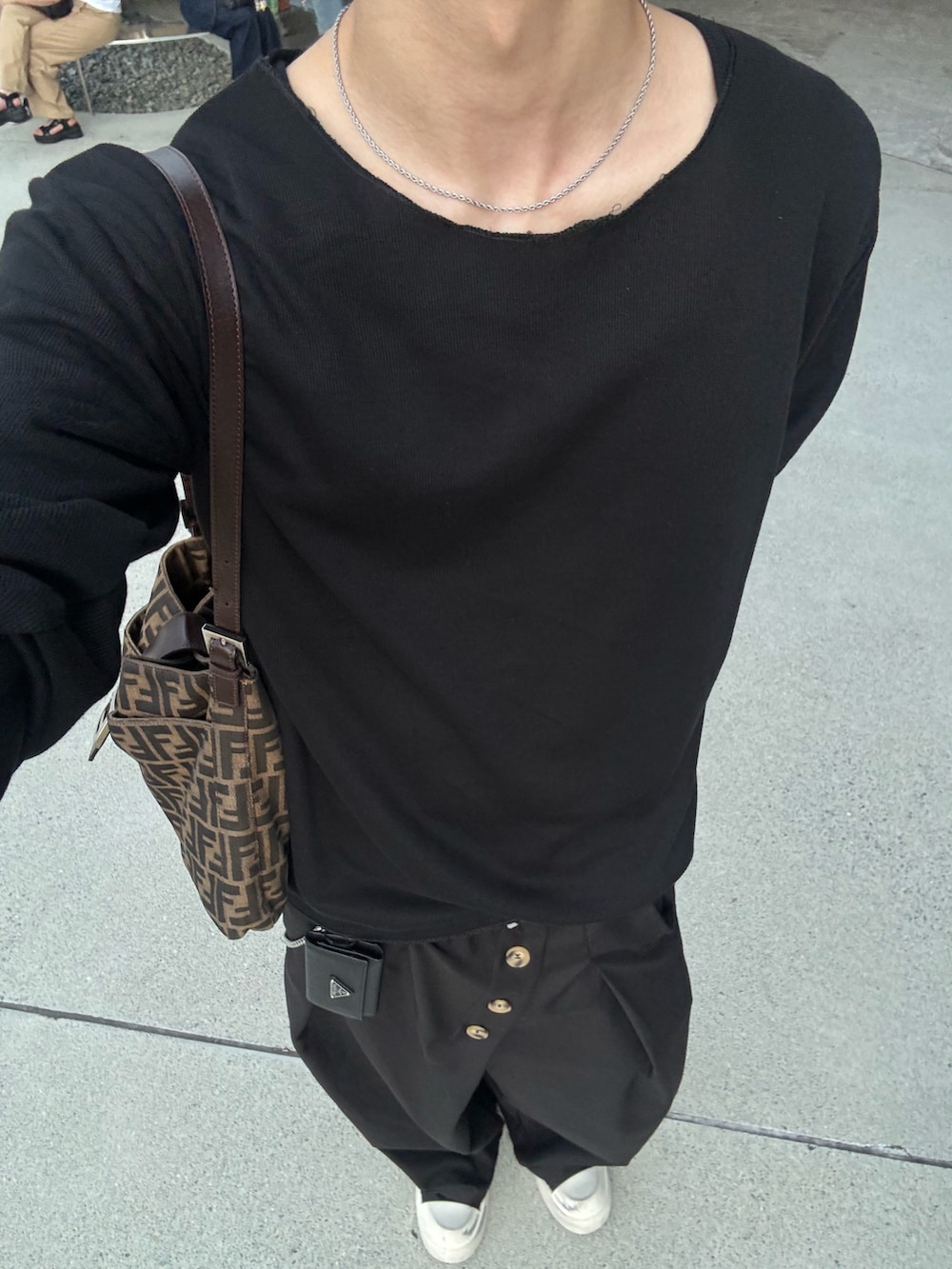 ブラック系のTシャツ/カットソー、ブラック系のスラックス、ブラック系のスニーカーを着用したメンズの夏コーディネートの5枚目の写真