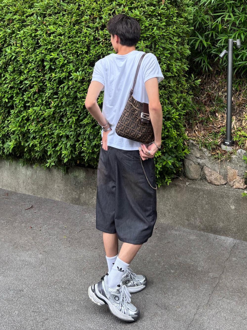 ホワイト系のスニーカー、ホワイト系のTシャツ/カットソー、ブラウン系のトートバッグを着用したメンズの夏コーディネートの3枚目の写真