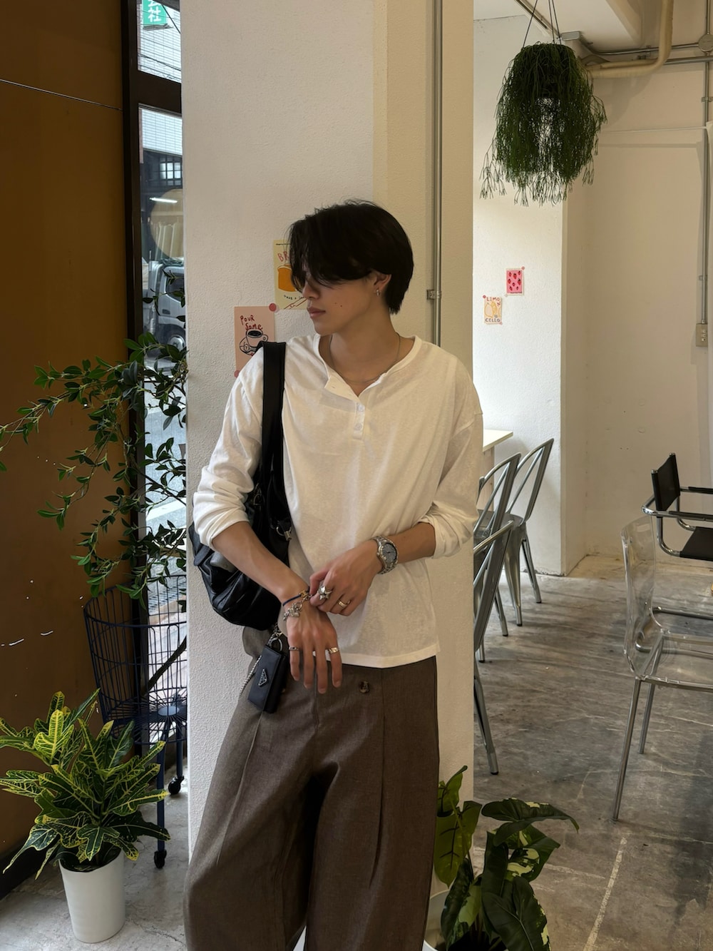 ホワイト系のTシャツ/カットソー、ブラウン系のスラックス、ブラック系のスニーカーを着用したメンズの夏コーディネートの4枚目の写真