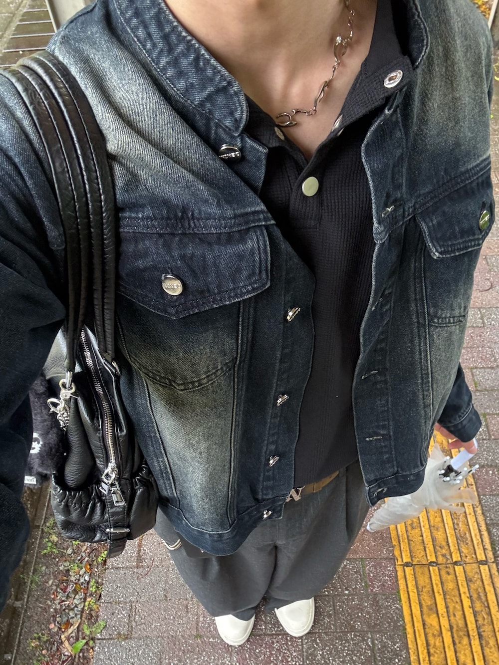 ブルー系のデニムジャケット、ブラック系のTシャツ/カットソー、グレー系のスラックスを着用したメンズの春コーディネートの3枚目の写真