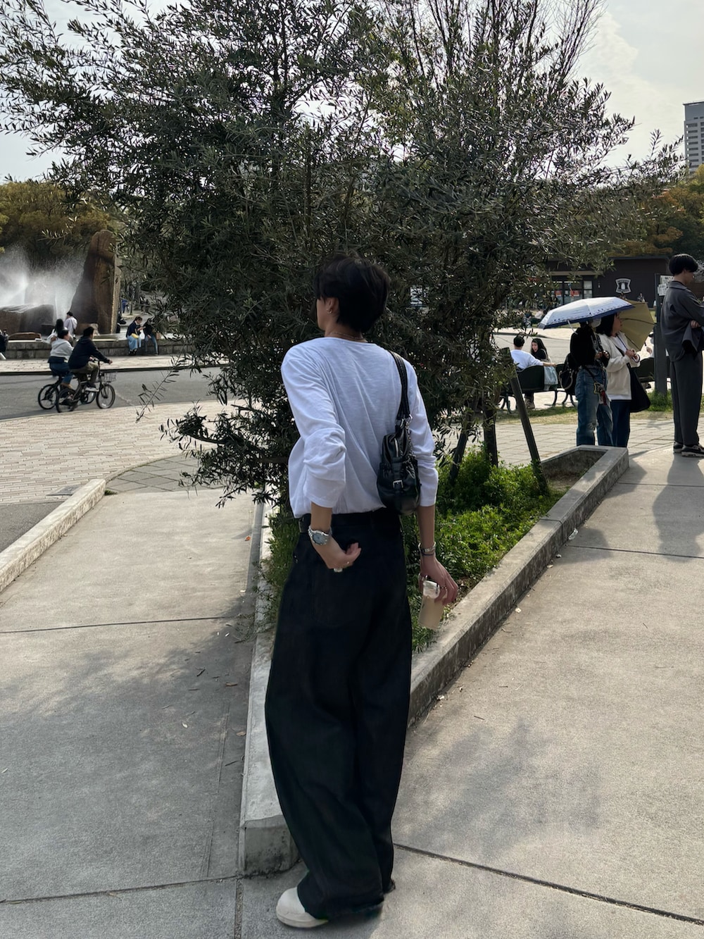 ホワイト系のTシャツ/カットソー、ブラック系のデニムパンツ、ブラック系のスニーカーを着用したメンズの春コーディネートの3枚目の写真