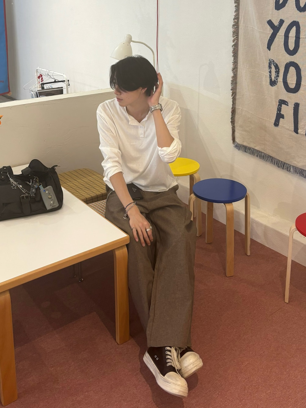 ホワイト系のTシャツ/カットソー、ブラウン系のスラックス、ブラック系のスニーカーを着用したメンズの夏コーディネートの3枚目の写真