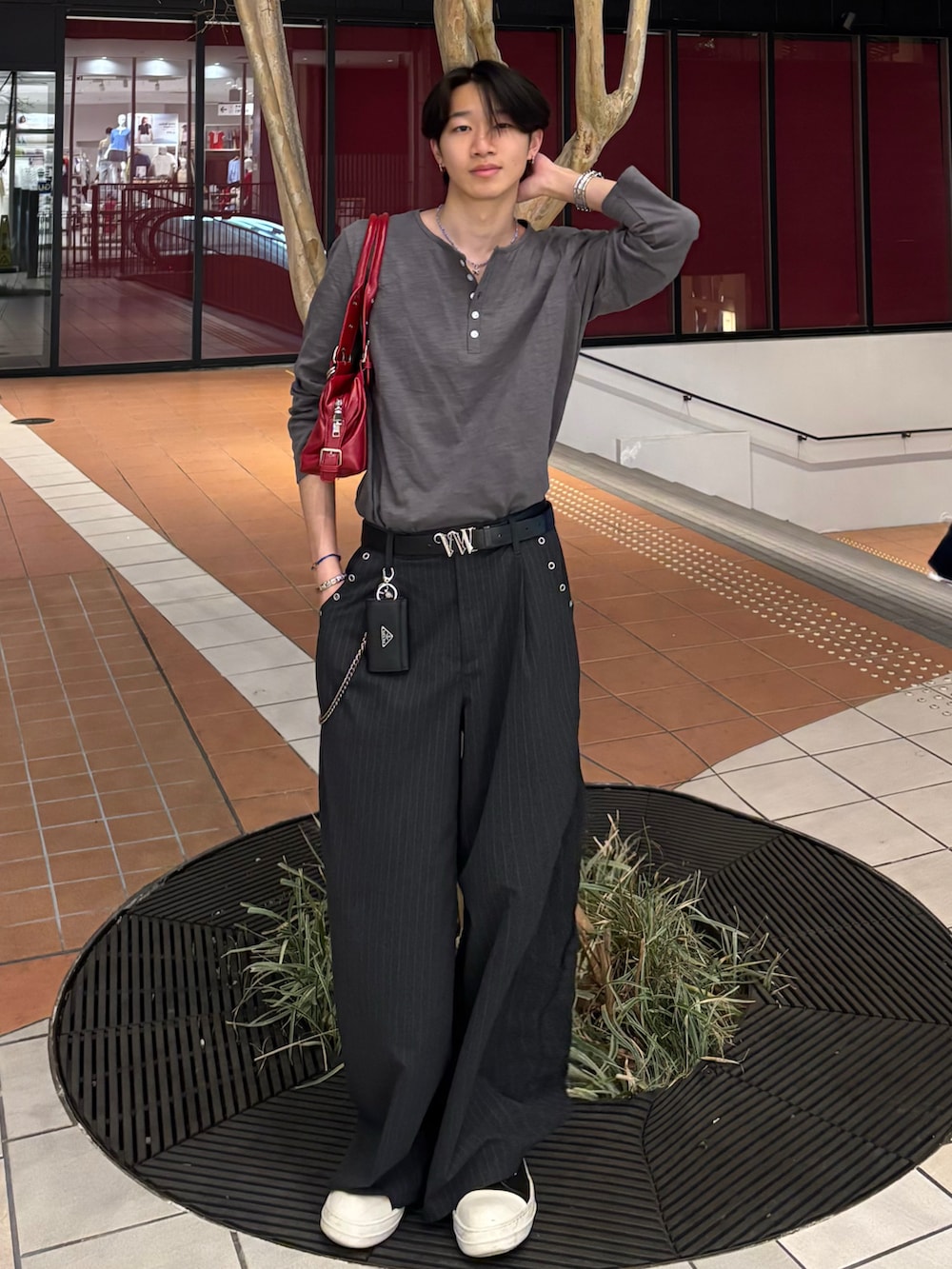 ホワイト系のTシャツ/カットソー、グレー系のスラックス、ブラック系のスニーカーを着用したメンズの春コーディネートの4枚目の写真