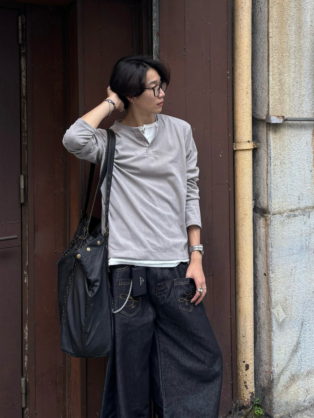 ベージュ系のTシャツ/カットソー、ブラック系のデニムパンツ、ブラック系のスニーカーを着用したメンズの秋コーディネートの4枚目の写真