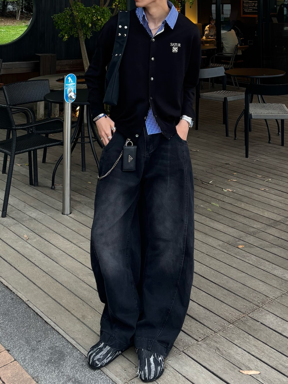 ブラック系のカーディガン/ボレロ、ブルー系のシャツ/ブラウス、ブラック系のデニムパンツを着用したメンズの春コーディネートの4枚目の写真