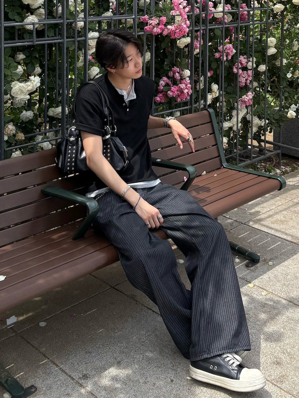 ブラック系のTシャツ/カットソー、ブルー系のデニムパンツ、ブラック系のスニーカーを着用したメンズの夏コーディネートの2枚目の写真