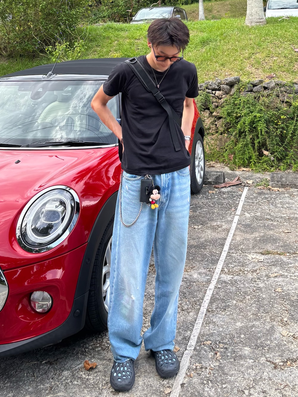 ブラック系のTシャツ/カットソー、ブルー系のデニムパンツ、ブラック系のサンダルを着用したメンズの夏コーディネートの2枚目の写真