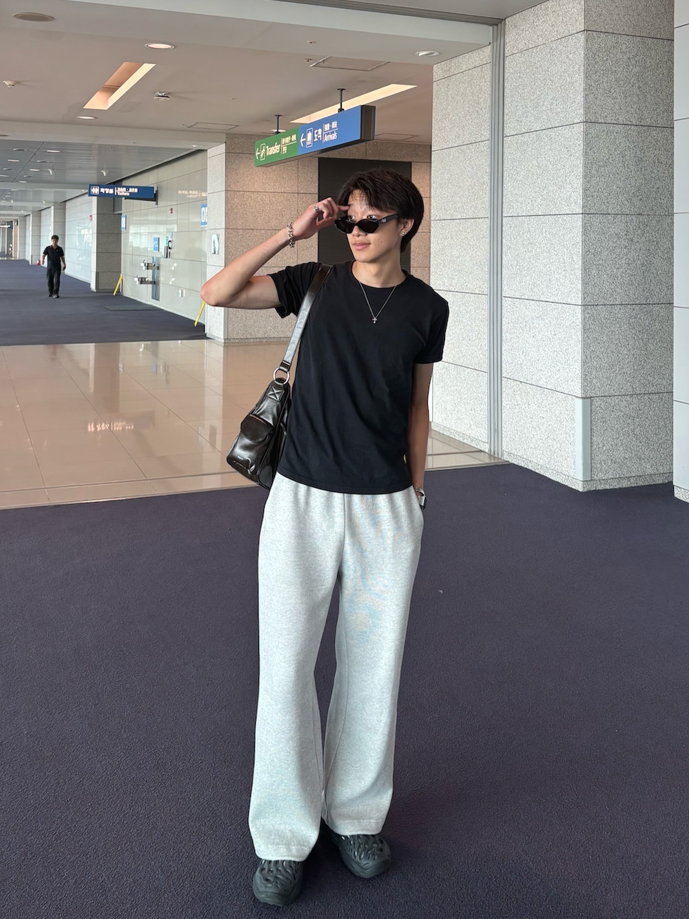 ブラック系のTシャツ/カットソー、グレー系のスウェットパンツ、ブラック系のサンダルを着用したメンズの夏コーディネートの2枚目の写真