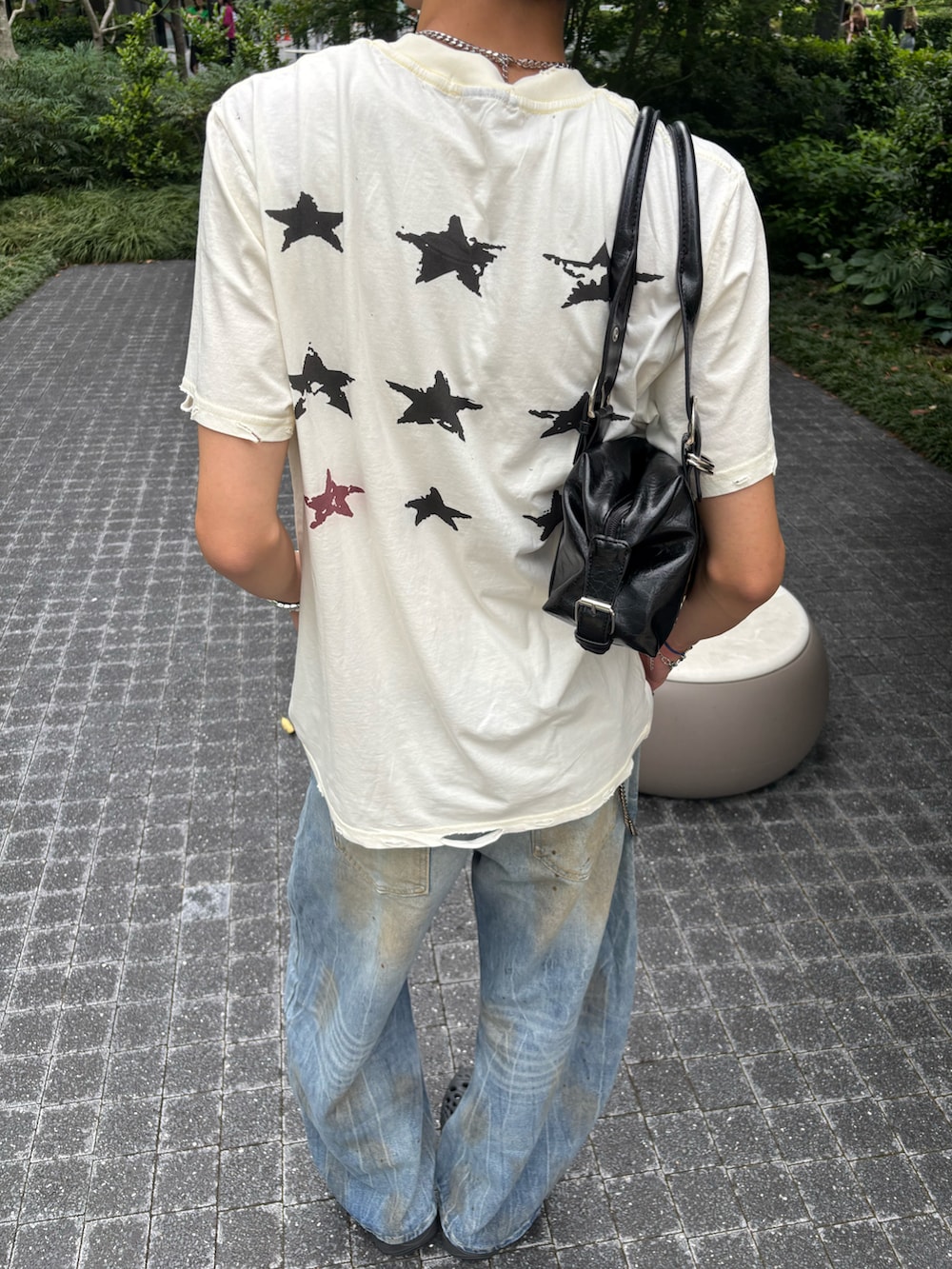 ホワイト系のTシャツ/カットソー、ブルー系のデニムパンツ、ブラック系のサンダルを着用したメンズの夏コーディネートの4枚目の写真