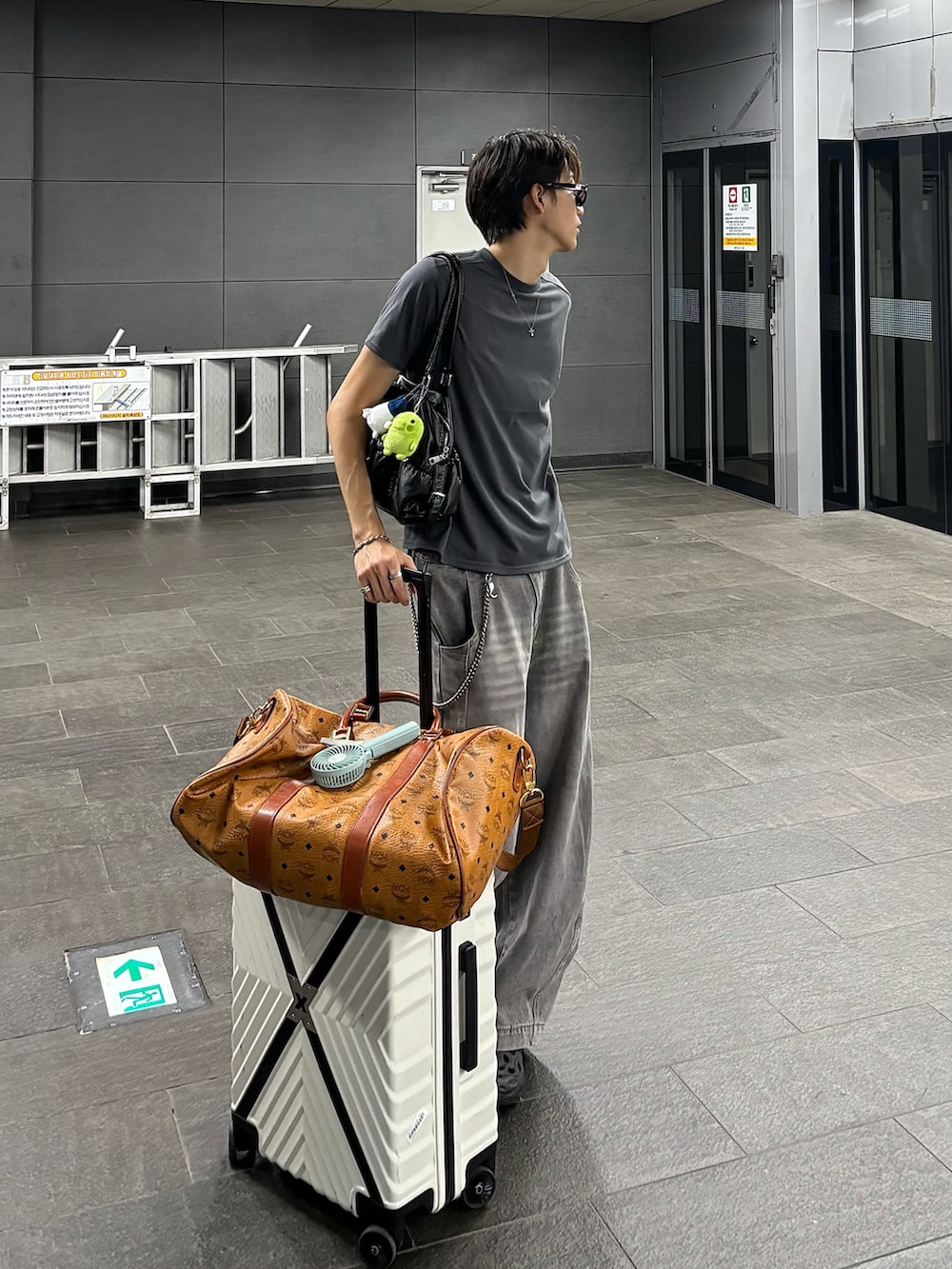 グレー系のTシャツ/カットソー、グレー系のデニムパンツ、ブラック系のサンダルを着用したメンズの秋コーディネートの2枚目の写真