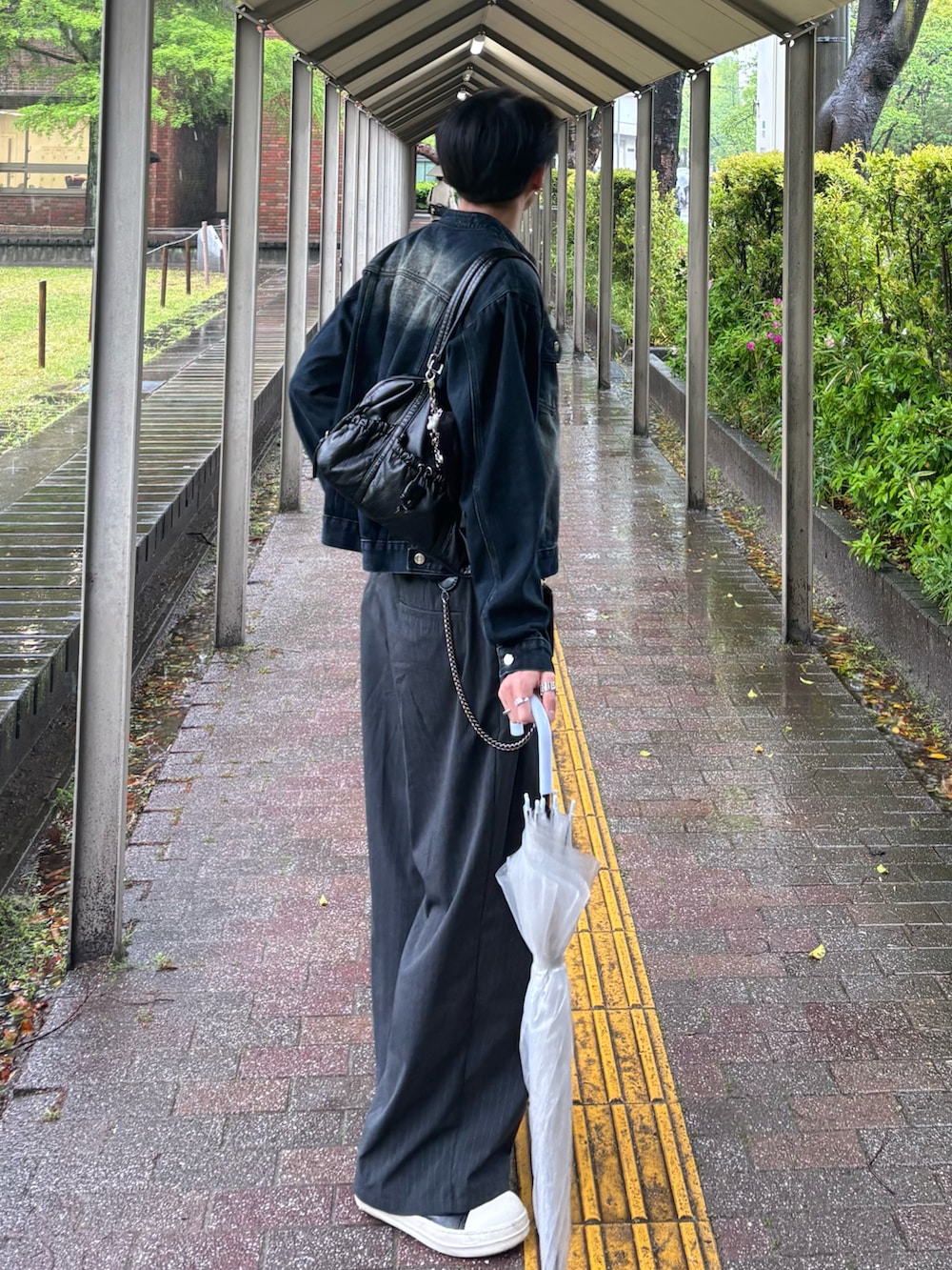 ブルー系のデニムジャケット、ブラック系のTシャツ/カットソー、グレー系のスラックスを着用したメンズの春コーディネートの4枚目の写真