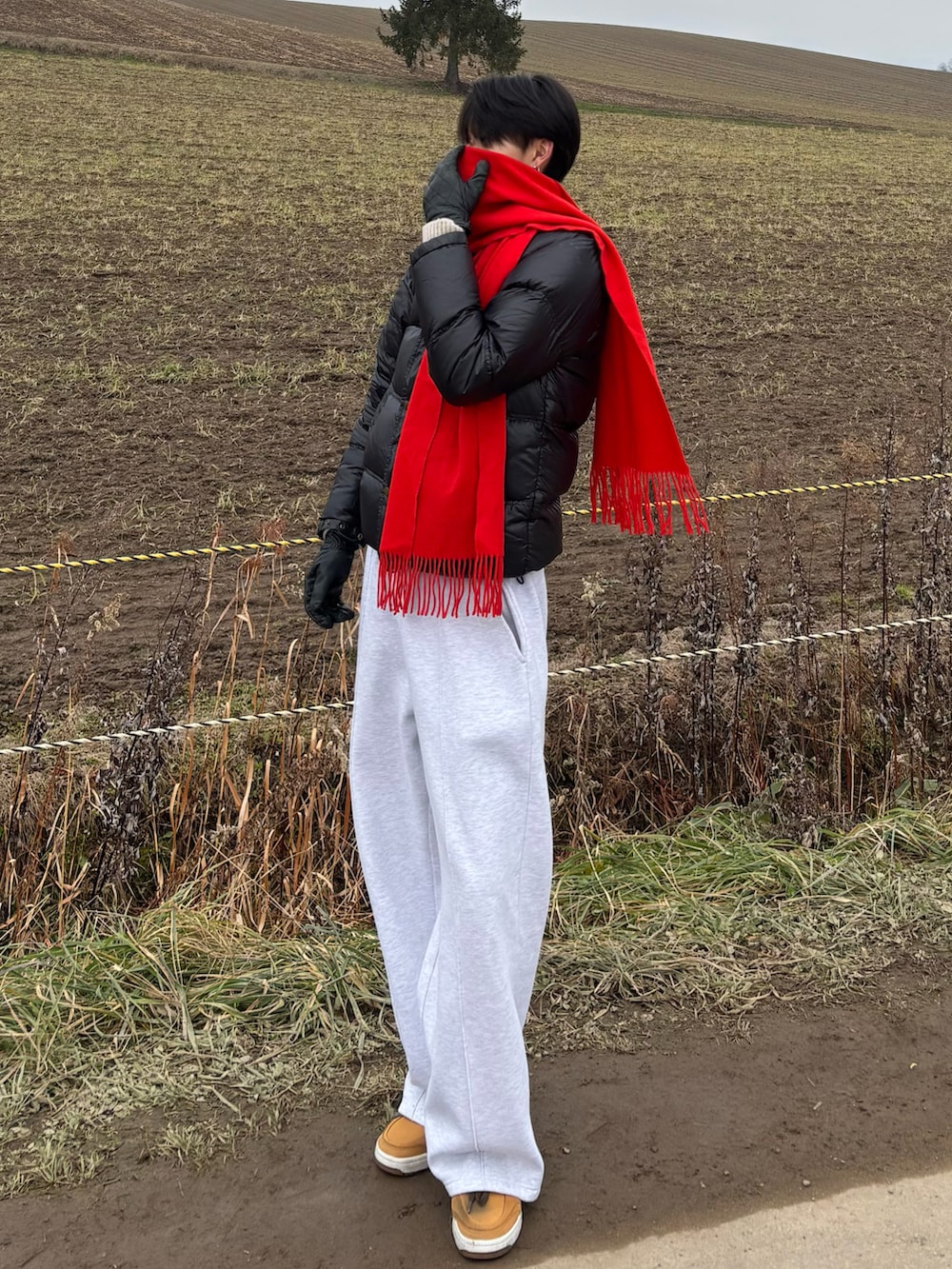 ブラウン系のショルダーバッグ、グレー系のスウェットパンツ、イエロー系のスニーカーを着用したメンズの秋コーディネートの2枚目の写真