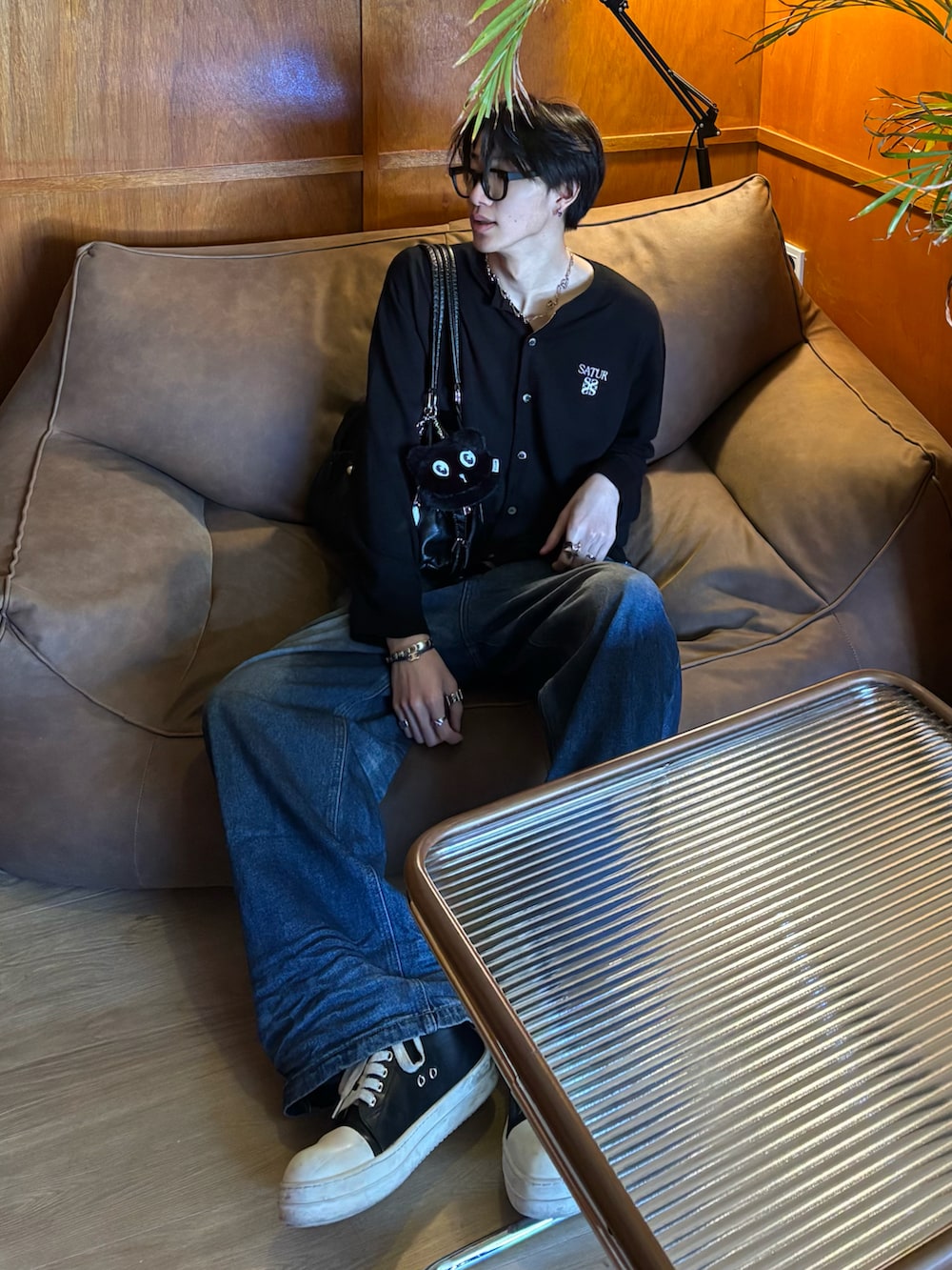 ブラック系のカーディガン/ボレロ、ブルー系のデニムパンツ、ブラック系のスニーカーを着用したメンズの冬コーディネートの5枚目の写真