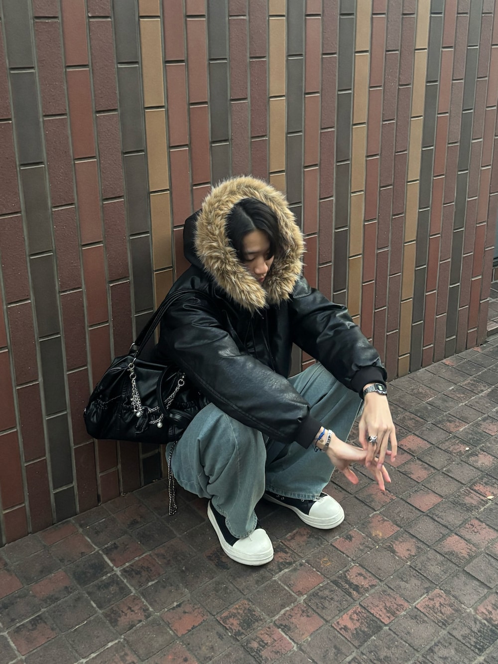 ブラック系のブルゾン、ブルー系のデニムパンツ、ブラック系のスニーカーを着用したメンズの冬コーディネートの2枚目の写真