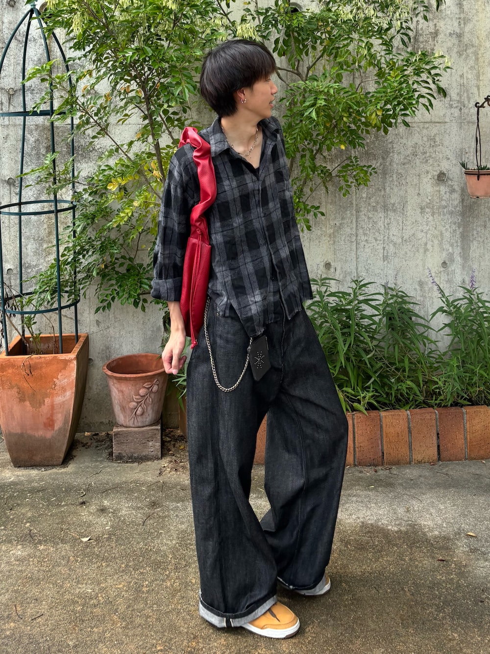 ブラック系のシャツ/ブラウス、ブラック系のデニムパンツ、レッド系のショルダーバッグを着用したメンズの秋コーディネートの3枚目の写真