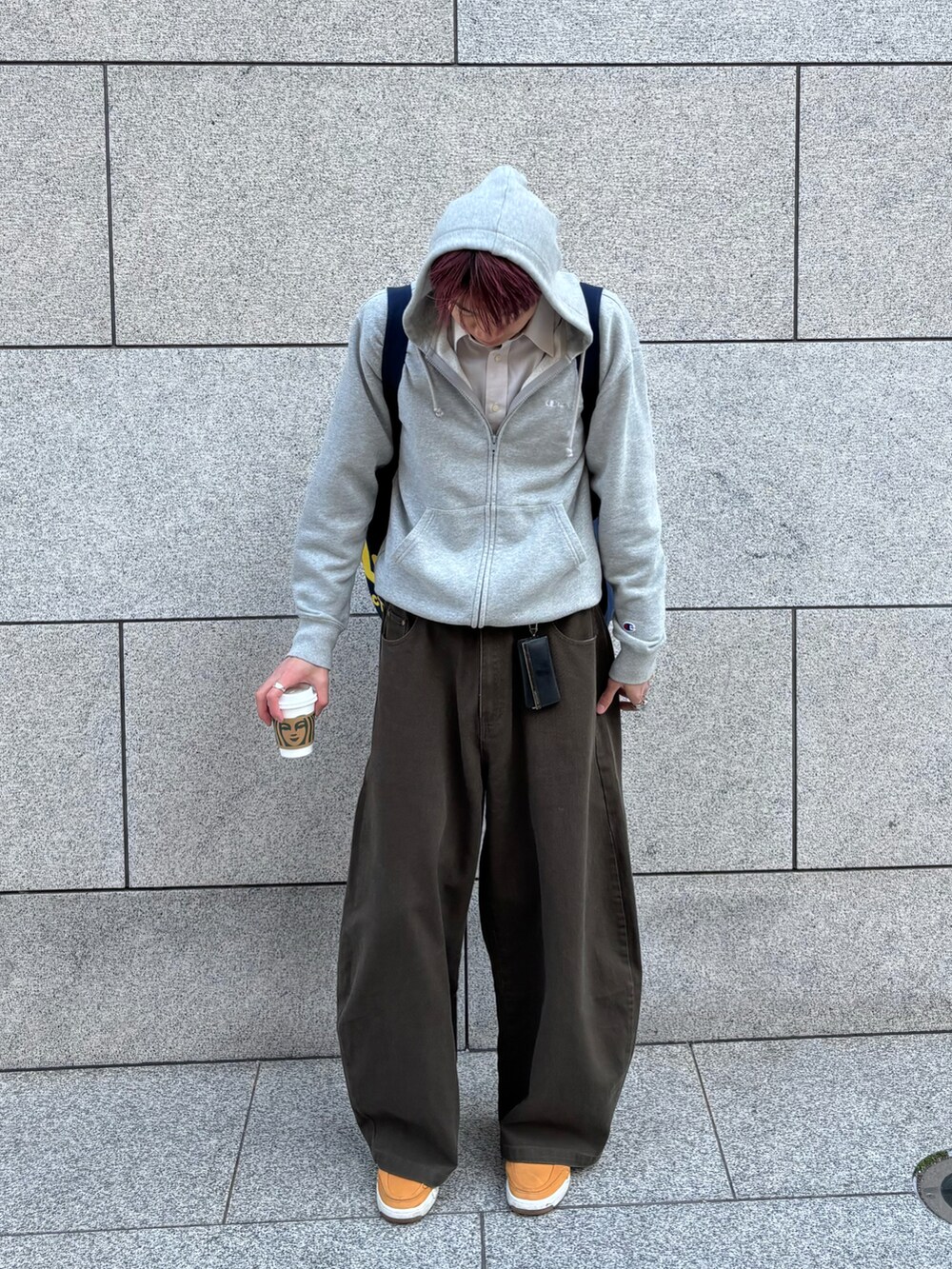 ブルー系のトートバッグ、グレー系のパーカー、グリーン系のチノパンツを着用したメンズの冬コーディネートの2枚目の写真