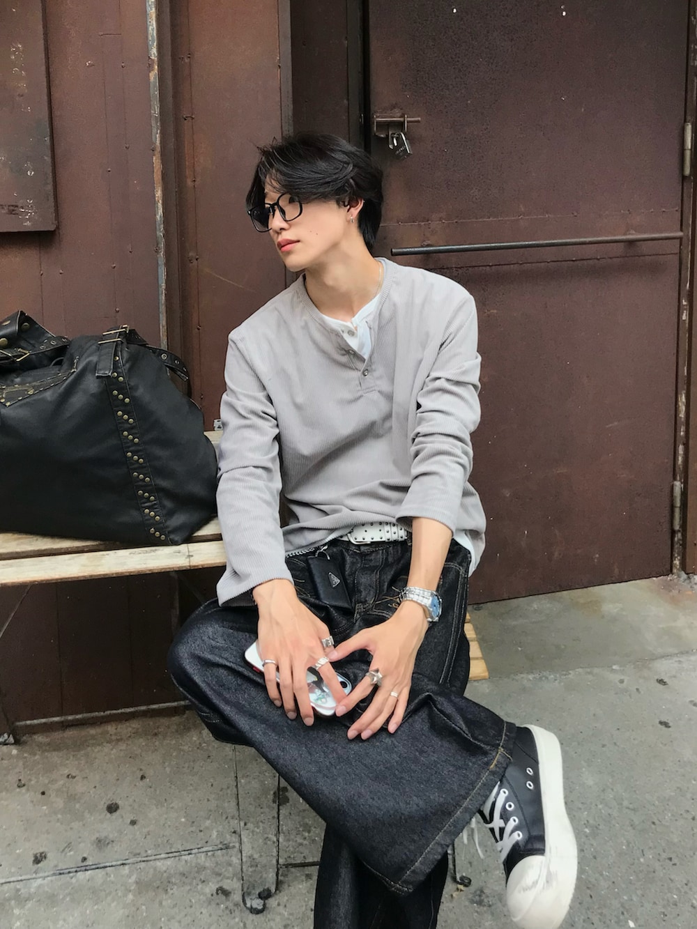 ベージュ系のTシャツ/カットソー、ブラック系のデニムパンツ、ブラック系のスニーカーを着用したメンズの秋コーディネートの5枚目の写真