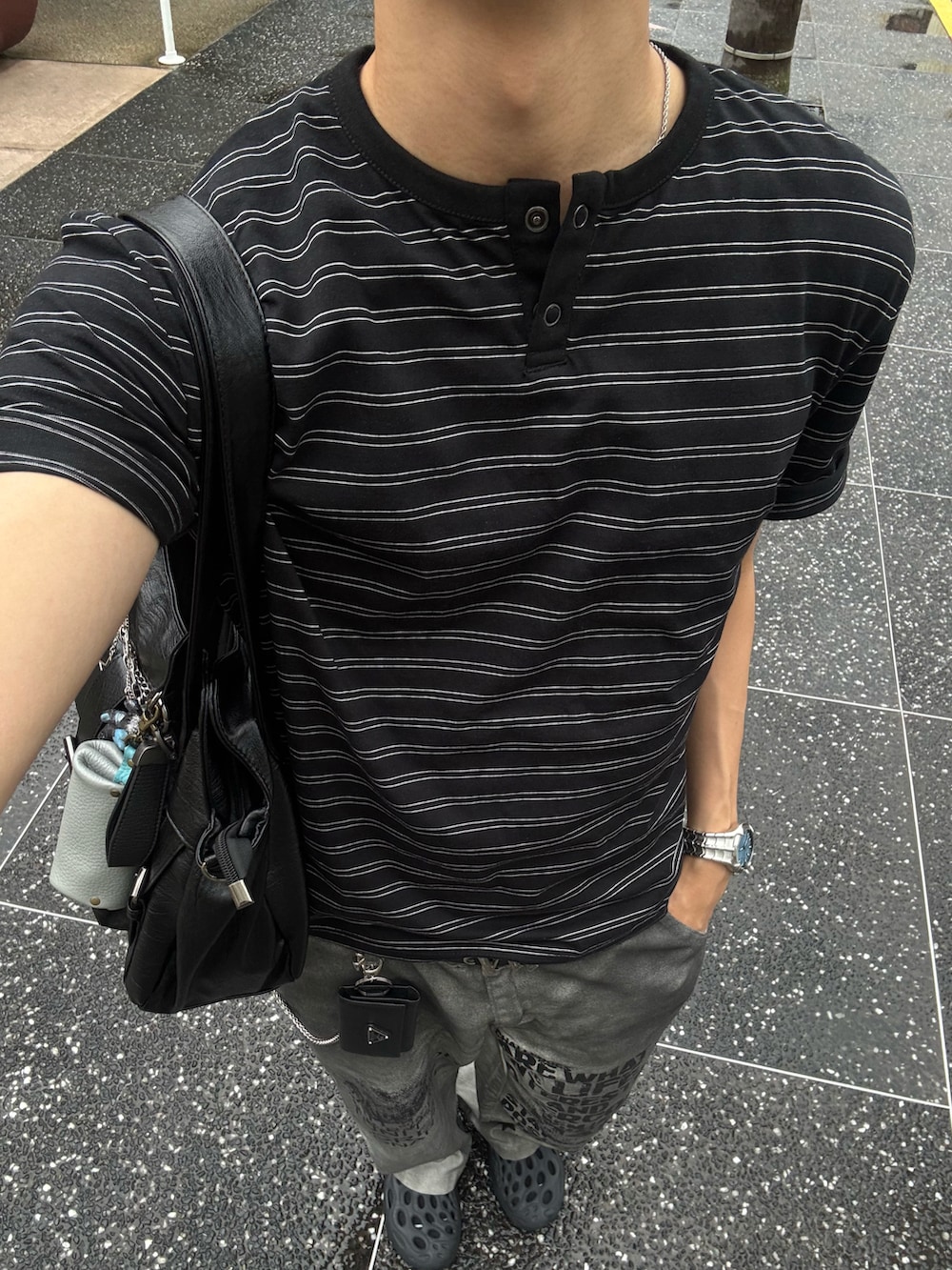 ブラック系のTシャツ/カットソー、ホワイト系のデニムパンツ、ブラック系のサンダルを着用したメンズの夏コーディネートの5枚目の写真