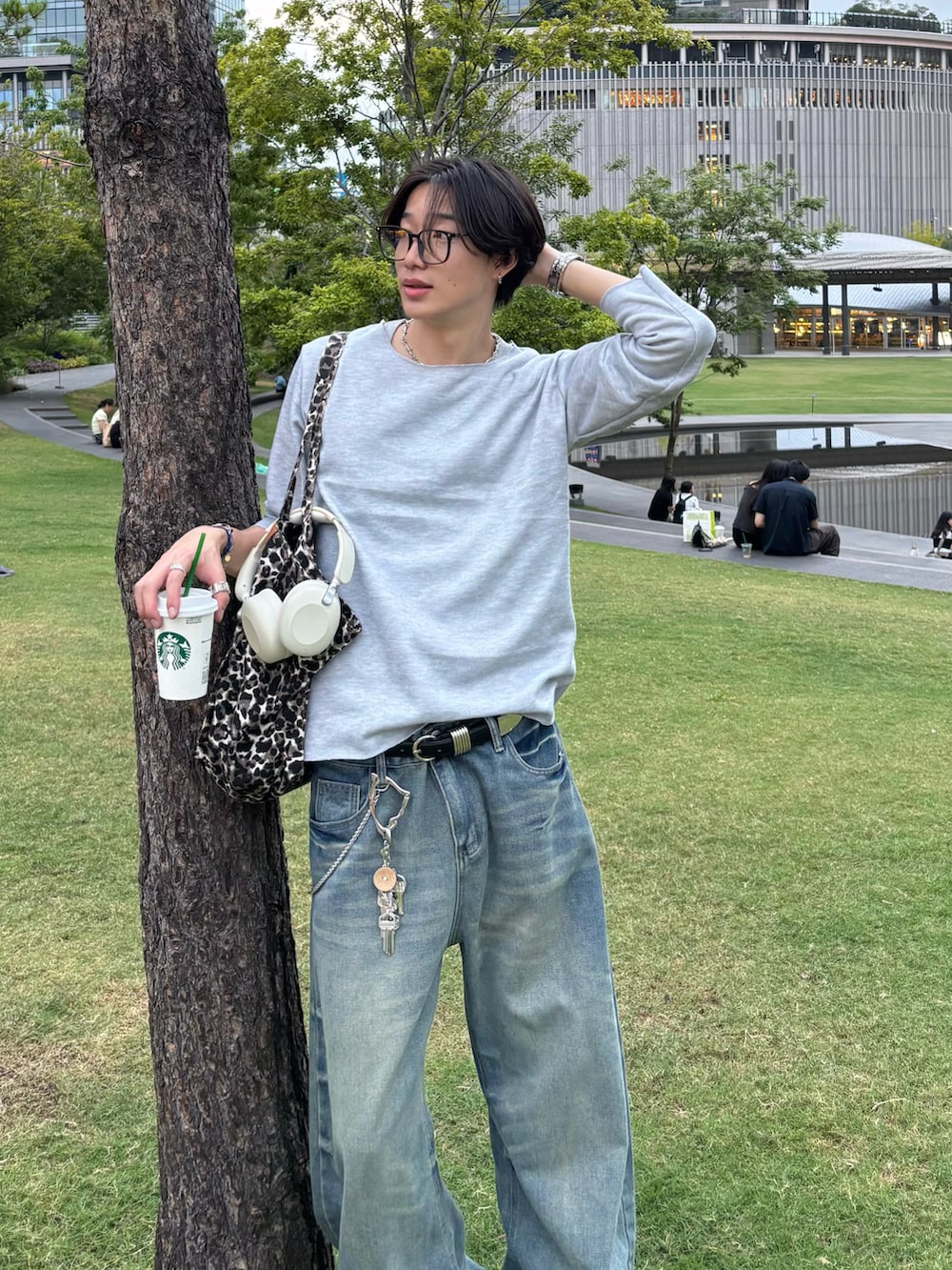 グレー系のTシャツ/カットソー、ブルー系のデニムパンツ、ブラック系のスニーカーを着用したメンズの秋コーディネートの4枚目の写真