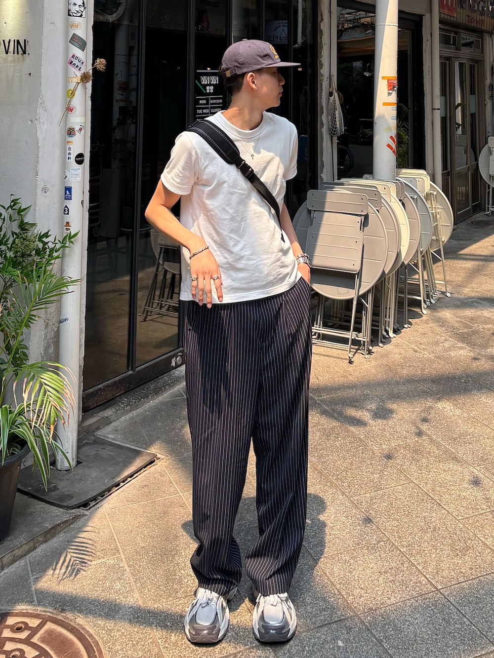 ホワイト系のTシャツ/カットソー、ブラック系のスラックス、ホワイト系のスニーカーを着用したメンズの春コーディネートの2枚目の写真