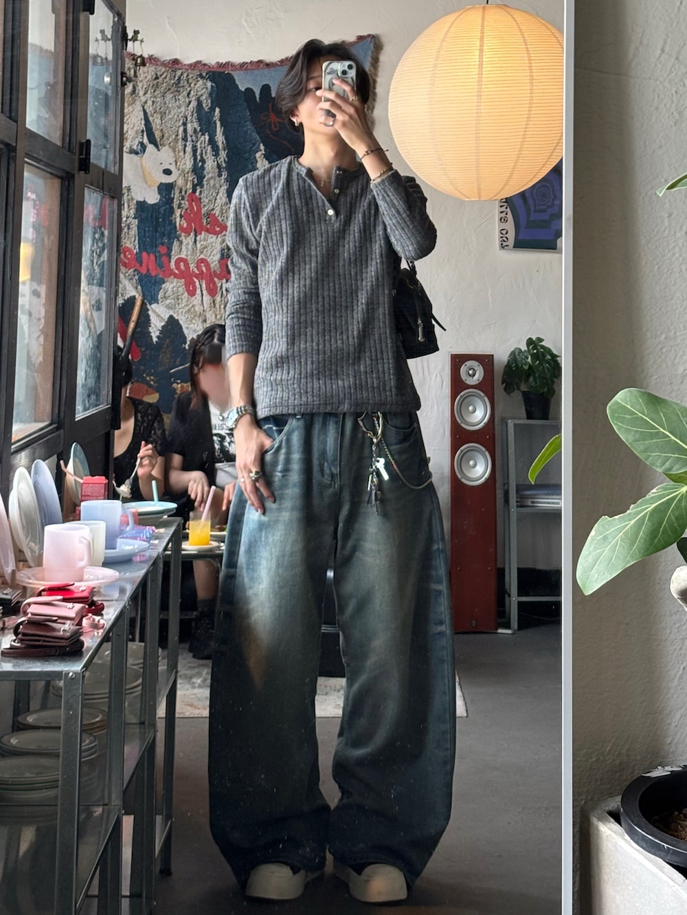 グレー系のTシャツ/カットソー、ブルー系のデニムパンツ、ブラック系のスニーカーを着用したメンズの秋コーディネートの4枚目の写真