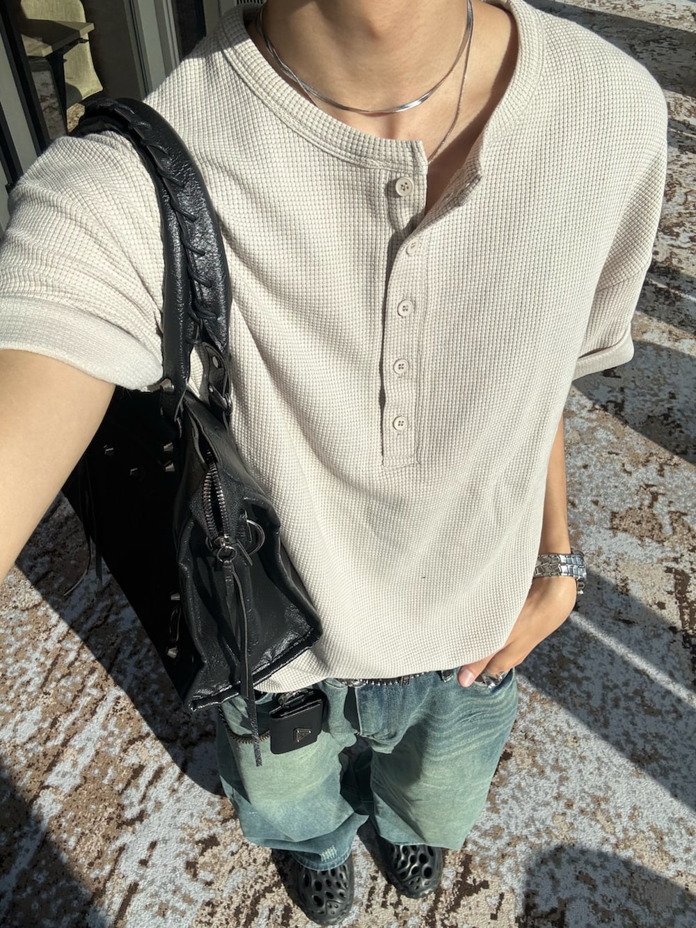 ベージュ系のTシャツ/カットソー、ブルー系のデニムパンツ、ブラック系のショルダーバッグを着用したメンズの春コーディネートの5枚目の写真