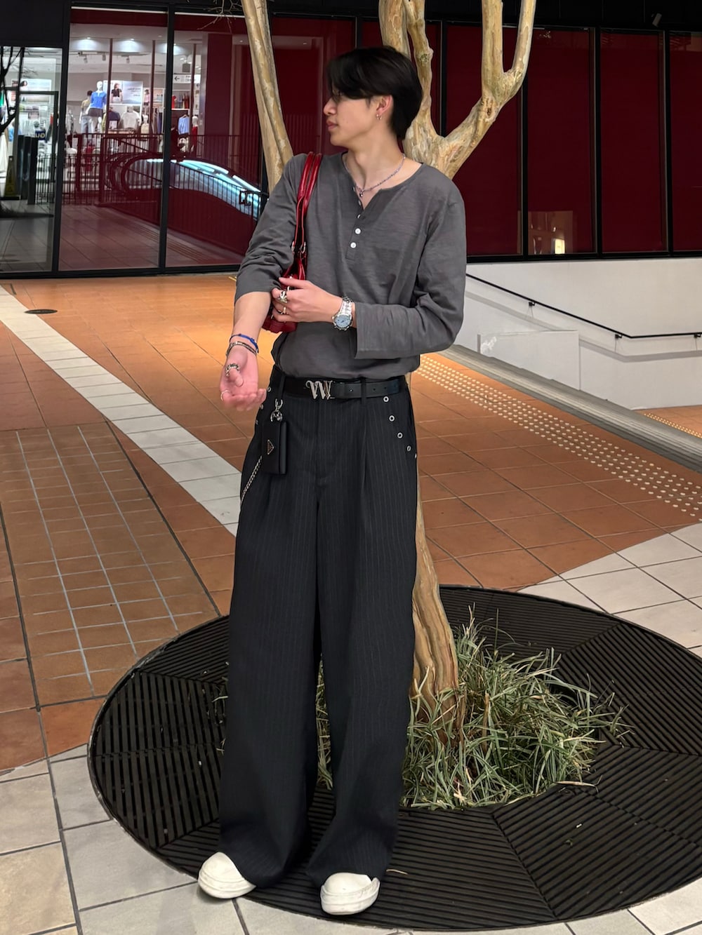 ホワイト系のTシャツ/カットソー、グレー系のスラックス、ブラック系のスニーカーを着用したメンズの春コーディネートの3枚目の写真