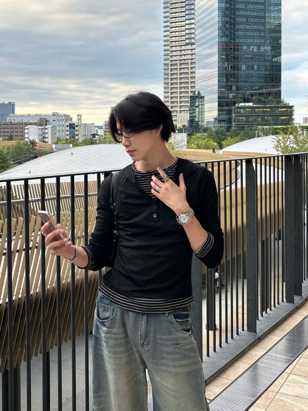 ブラック系のTシャツ/カットソー、ブルー系のデニムパンツ、ブラック系のスニーカーを着用したメンズの秋コーディネートの4枚目の写真