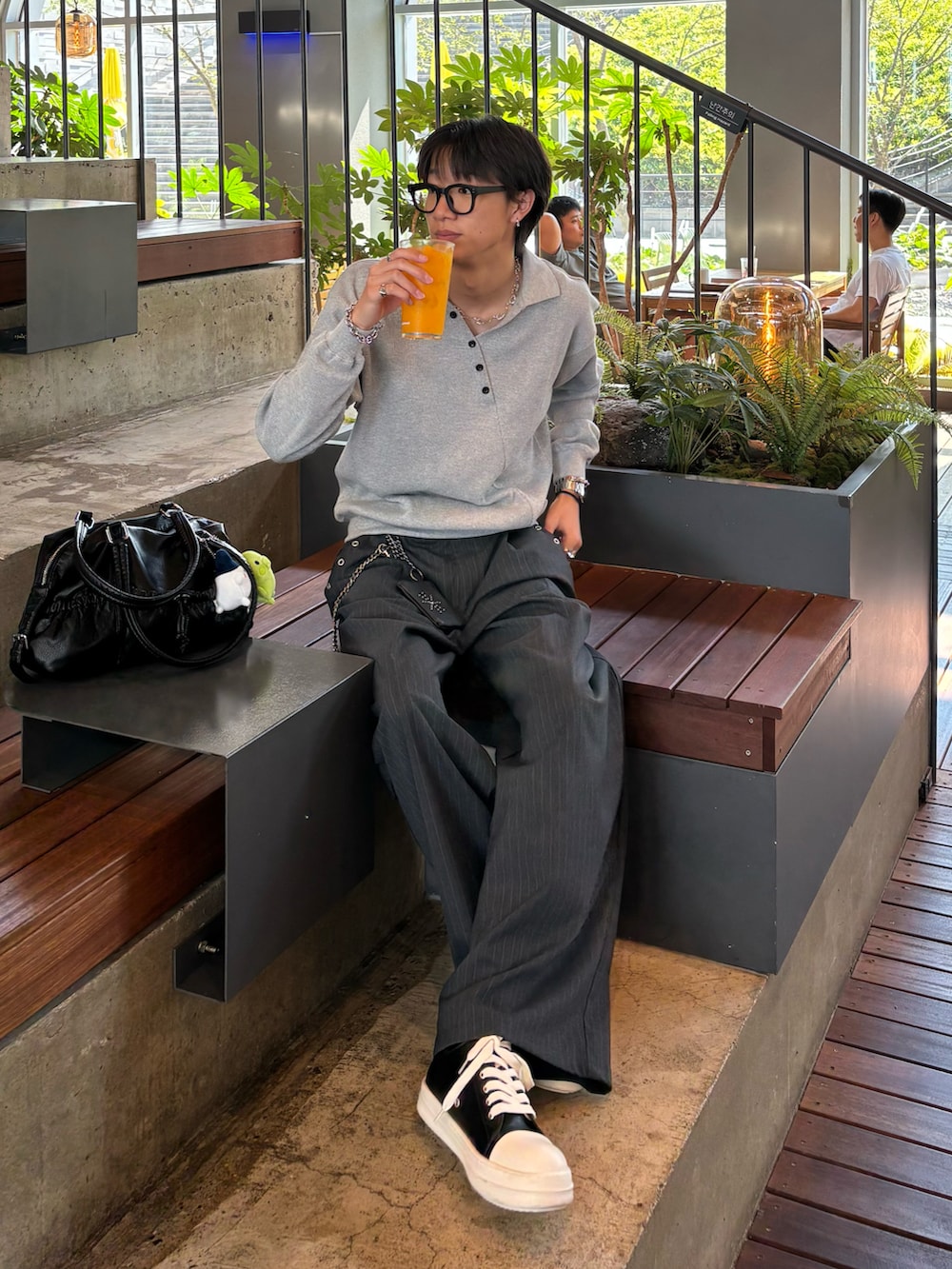 グレー系のポロシャツ、グレー系のスラックス、ブラック系のトートバッグを着用したメンズの秋コーディネートの2枚目の写真