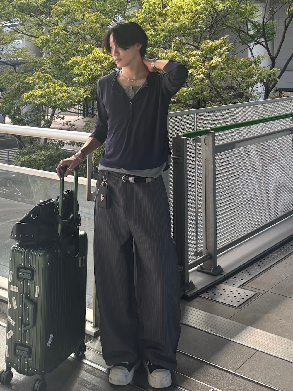 ブルー系のTシャツ/カットソー、グレー系のスラックス、ブラック系のスニーカーを着用したメンズの秋コーディネートの3枚目の写真