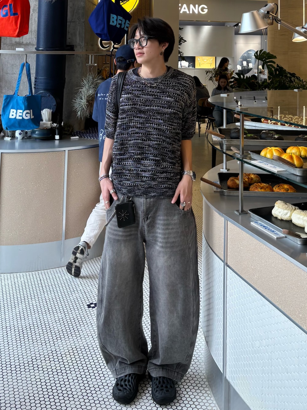 ブラック系のTシャツ/カットソー、グレー系のデニムパンツ、ブラック系のサンダルを着用したメンズの春コーディネートの2枚目の写真