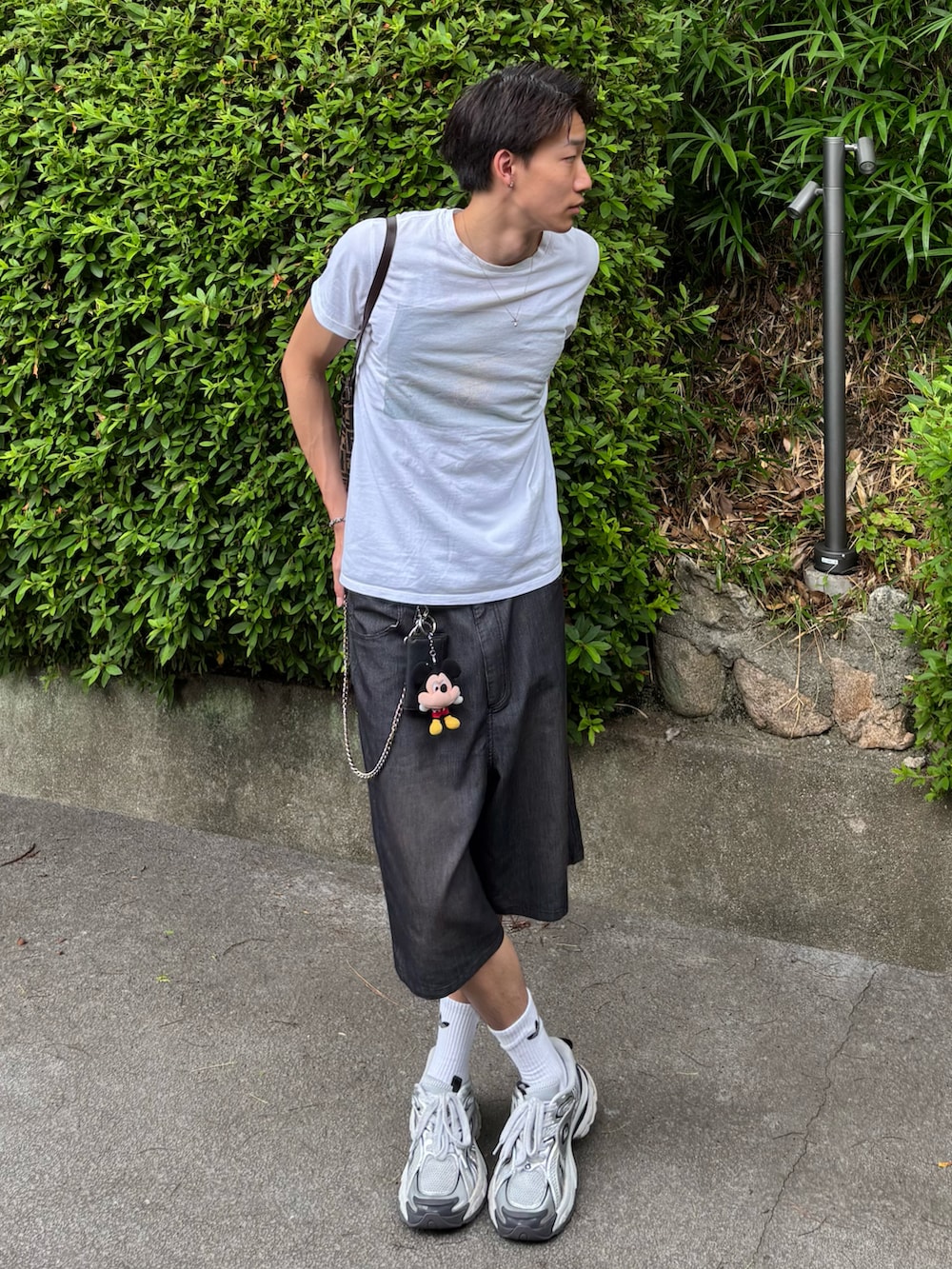 ホワイト系のスニーカー、ホワイト系のTシャツ/カットソー、ブラウン系のトートバッグを着用したメンズの夏コーディネートの2枚目の写真