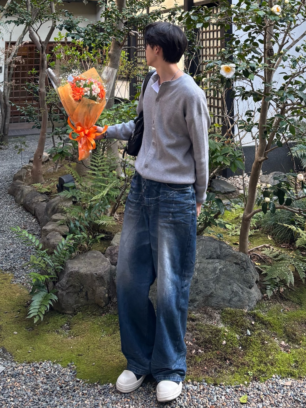 グレー系のカーディガン/ボレロ、ホワイト系のTシャツ/カットソー、ブルー系のデニムパンツを着用したメンズの春コーディネートの2枚目の写真