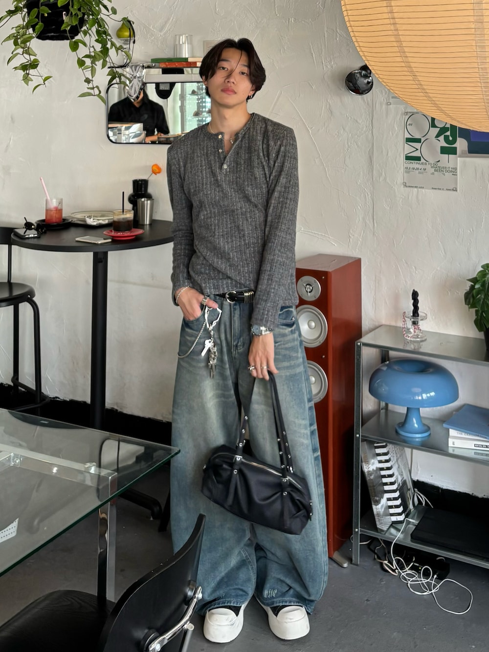グレー系のTシャツ/カットソー、ブルー系のデニムパンツ、ブラック系のスニーカーを着用したメンズの秋コーディネートの3枚目の写真
