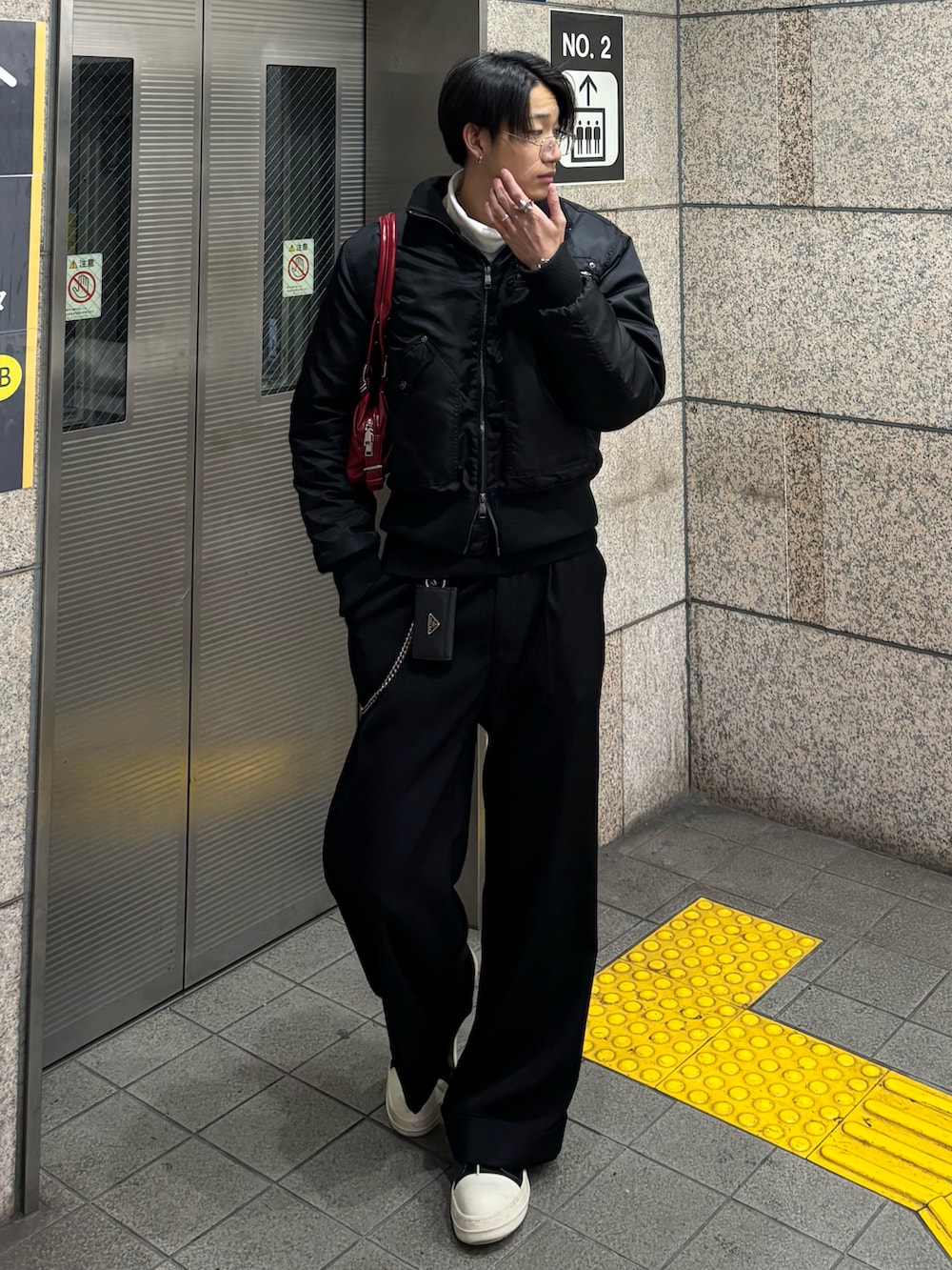 ブラック系のジャケット/アウター、ホワイト系のTシャツ/カットソー、ブラック系のスラックスを着用したメンズの冬コーディネートの2枚目の写真