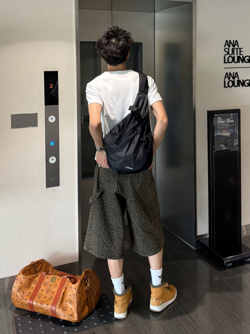 ホワイト系のTシャツ/カットソー、ブラウン系のデニムパンツ、ベージュ系のスニーカーを着用したメンズの夏コーディネートの3枚目の写真