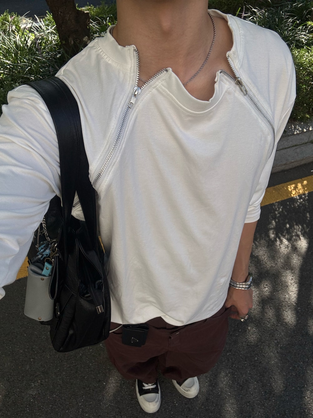 ホワイト系のTシャツ/カットソー、ブラウン系のチノパンツ、ブラック系のスニーカーを着用したメンズの夏コーディネートの5枚目の写真