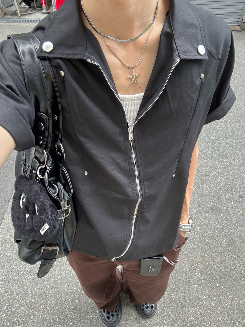 ブラック系のシャツ/ブラウス、ブラウン系のチノパンツ、ブラック系のサンダルを着用したメンズの春コーディネートの5枚目の写真