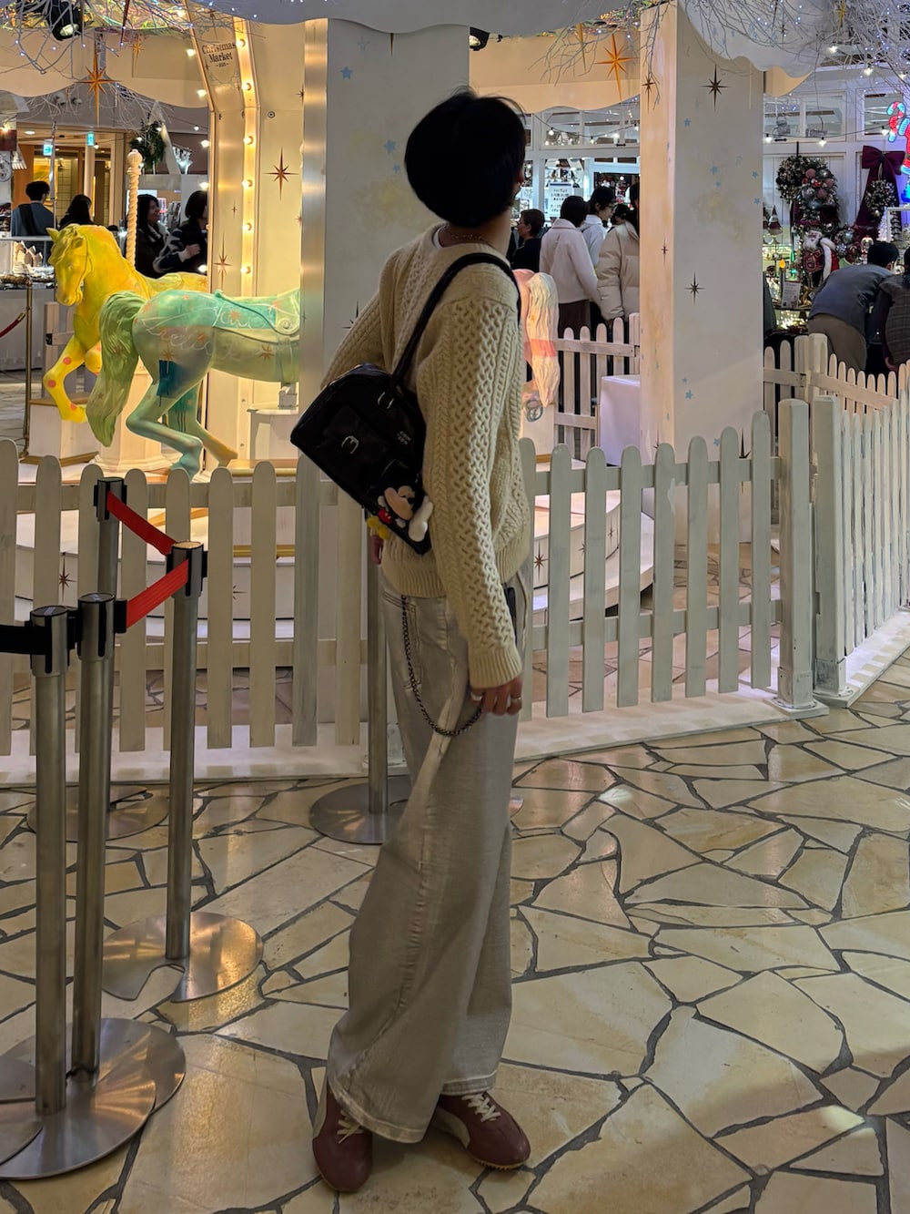 ホワイト系のニット/セーター、ホワイト系のデニムパンツ、ブラウン系のショルダーバッグを着用したメンズの冬コーディネートの2枚目の写真