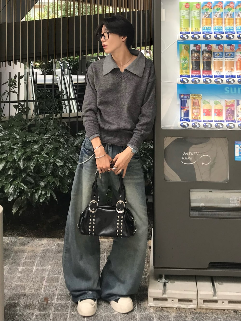 ブルー系のデニムパンツ、ブラック系のスニーカー、グレー系のニット/セーターを着用したメンズの秋コーディネートの2枚目の写真