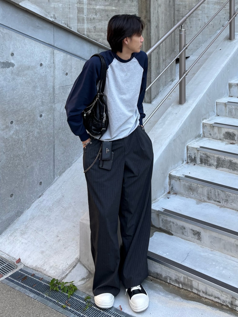 ブルー系のスウェット、グレー系のスラックス、ブラック系のスニーカーを着用したメンズの秋コーディネートの2枚目の写真