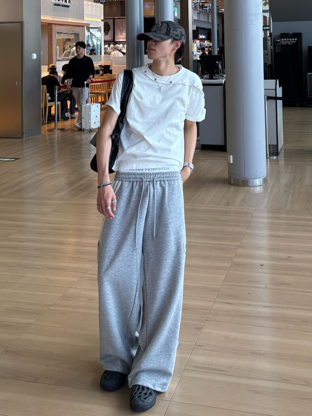 ホワイト系のTシャツ/カットソー、グレー系のスウェットパンツ、ブラック系のサンダルを着用したメンズの夏コーディネートの2枚目の写真