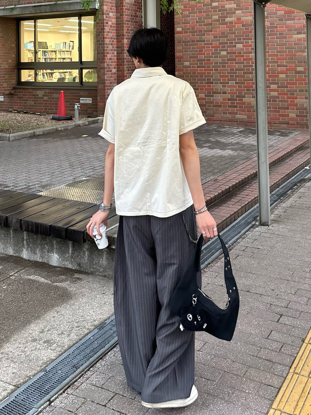 ホワイト系のシャツ/ブラウス、グレー系のスラックス、ブラック系のスニーカーを着用したメンズの春コーディネートの4枚目の写真