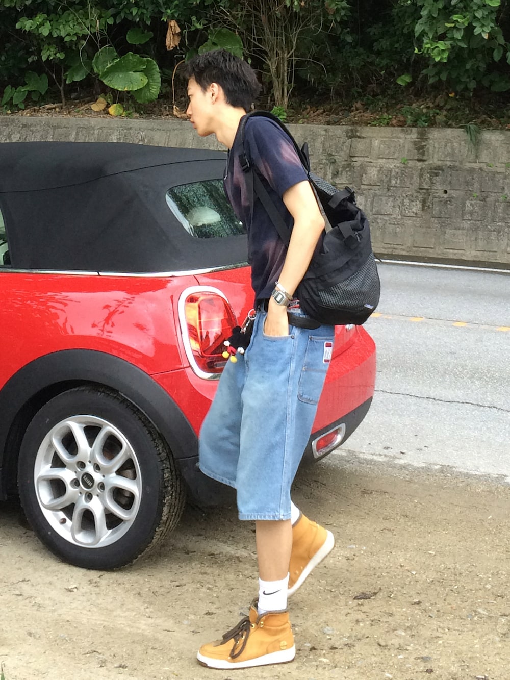 ブルー系のTシャツ/カットソー、ブラック系のショルダーバッグ、ブルー系のデニムパンツを着用したメンズの夏コーディネートの2枚目の写真