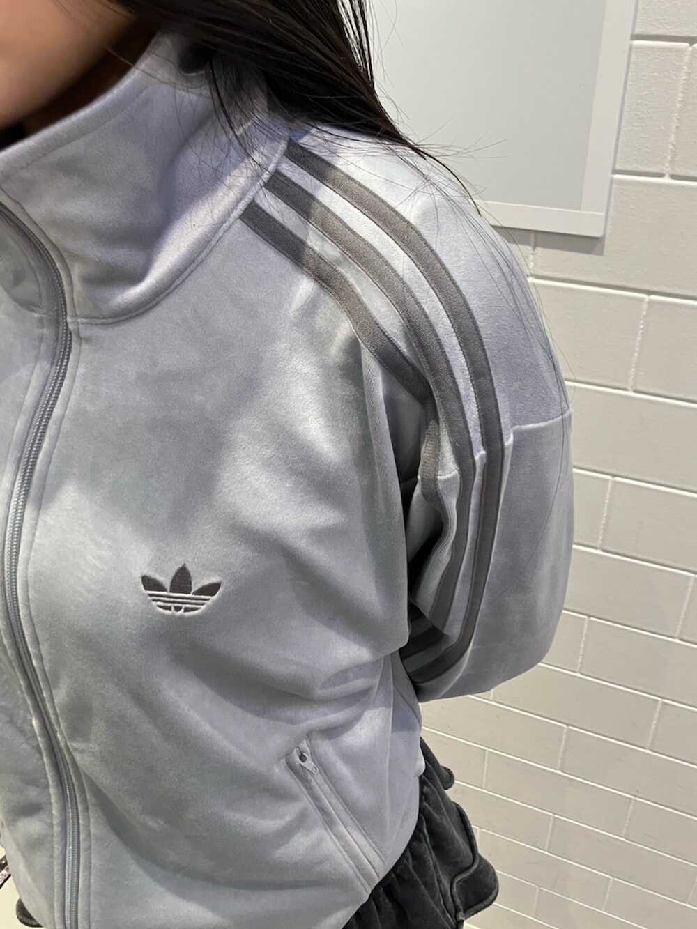 グレー系のジャージ、グレー系のショルダーバッグ、ブラック系のスニーカーを着用したレディースの冬コーディネートの2枚目の写真