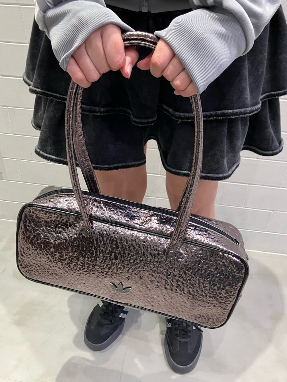 グレー系のジャージ、グレー系のショルダーバッグ、ブラック系のスニーカーを着用したレディースの冬コーディネートの3枚目の写真