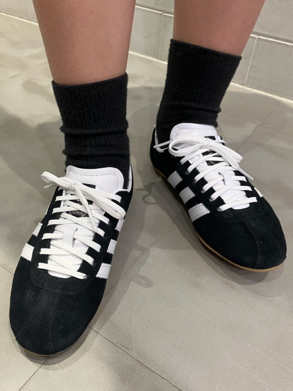 ブラック系のTシャツ/カットソー、ブラック系のスニーカー、ブラック系のパンツを着用したレディースの夏コーディネートの4枚目の写真