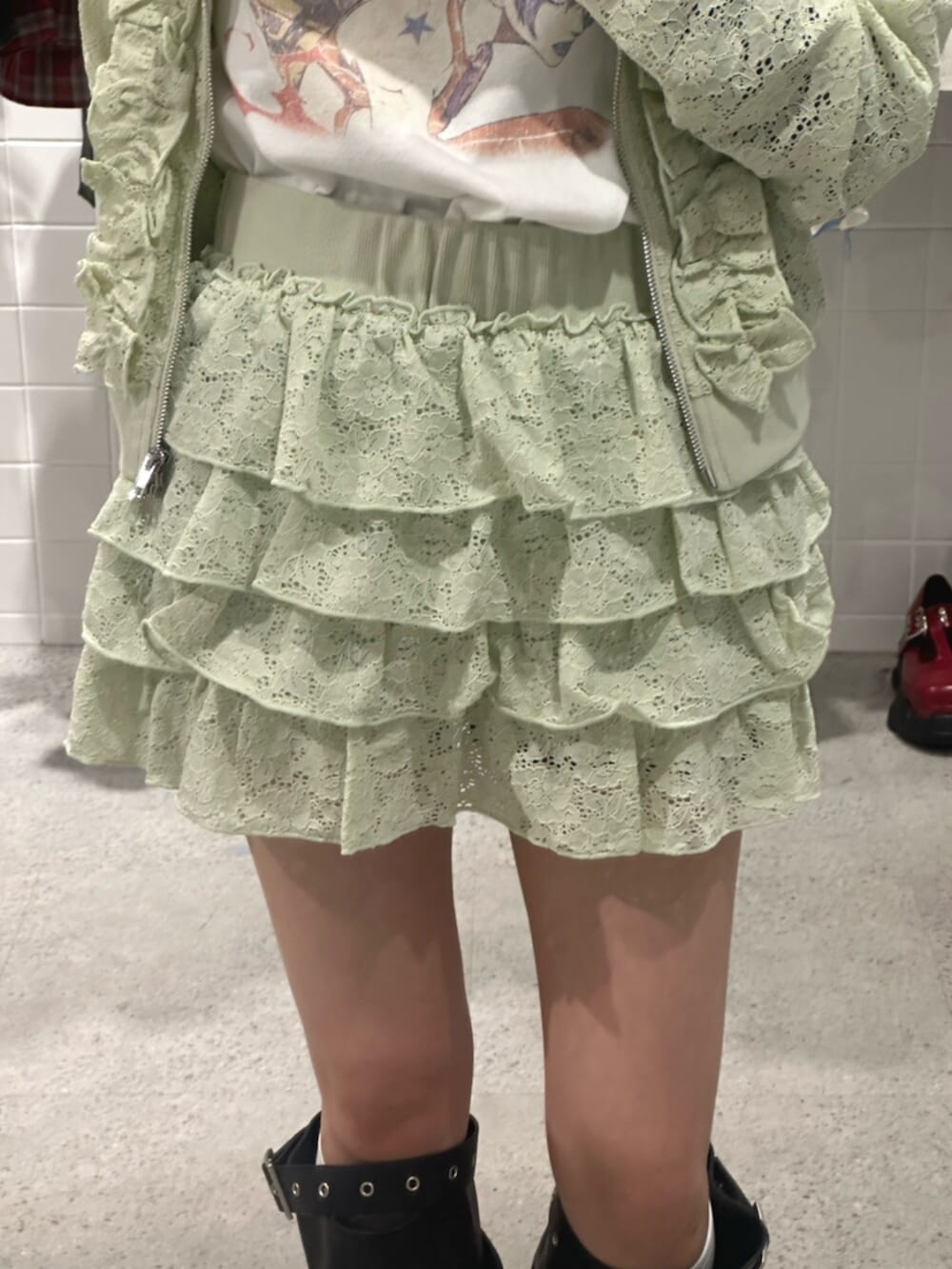 グリーン系のパーカー、グリーン系のスカート、ホワイト系のTシャツ/カットソーを着用したレディースの春コーディネートの7枚目の写真