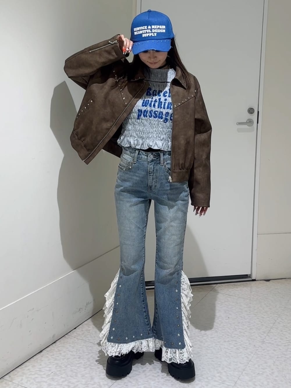 グレー系のTシャツ/カットソー、ブラウン系のブルゾン、ブルー系のローファーを着用したレディースの冬コーディネートの3枚目の写真