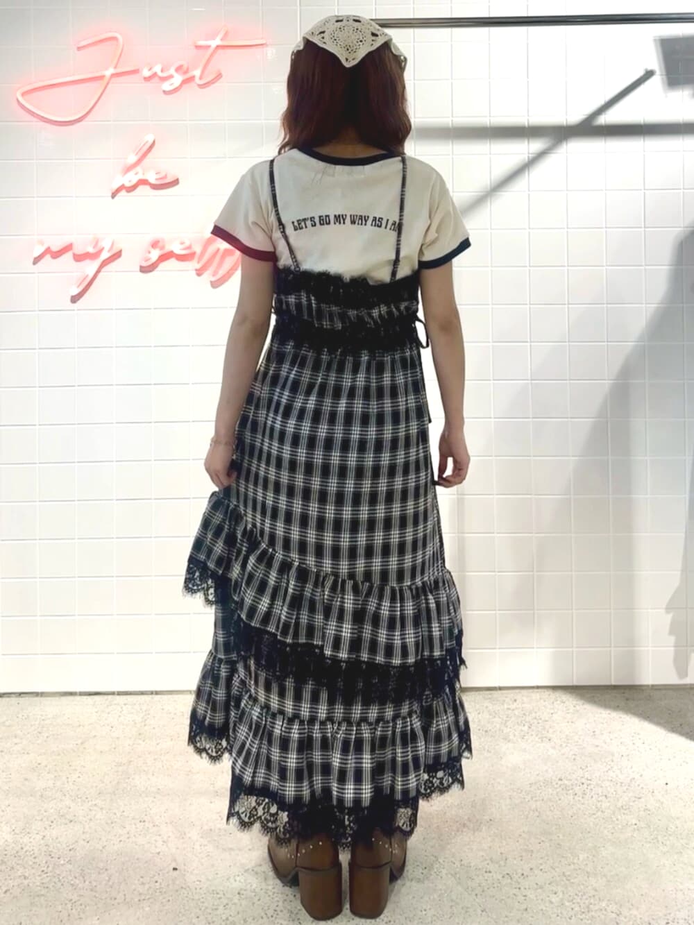 ブラック系のブーツ、ブラック系のワンピース、ホワイト系のTシャツ/カットソーを着用したレディースの夏コーディネートの5枚目の写真